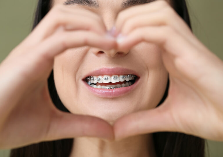 Close Of Of Smiling Girl Holding Her Hands Like A Heart 1