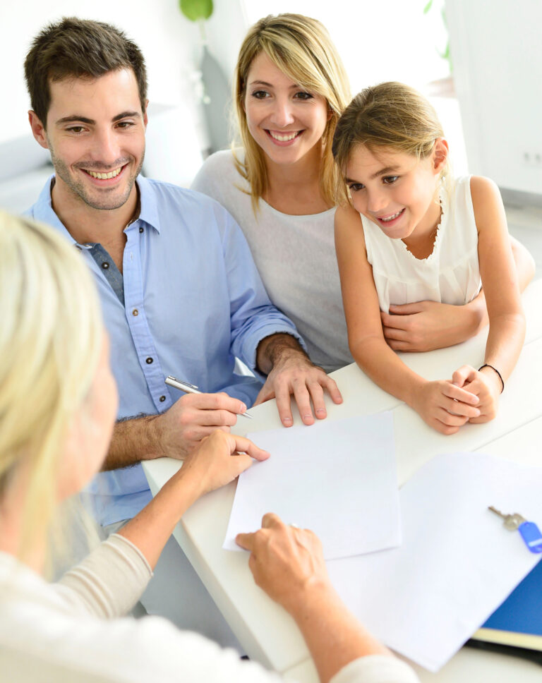 Family Sitting Down With Orthodontist Filling Out Financial Information