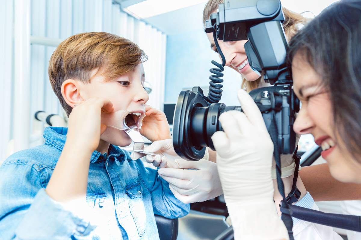 Orthodontic Patient With Staff Members Taking A Photo Of Teeth With Mouth Option