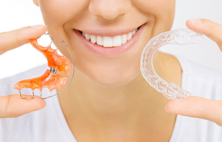 Woman Holding Two Pairs Of Retainers